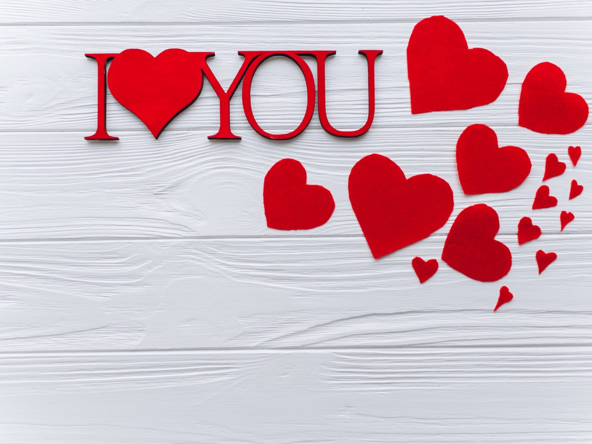 Надпись Я тебя люблю с красными сердечками на столе