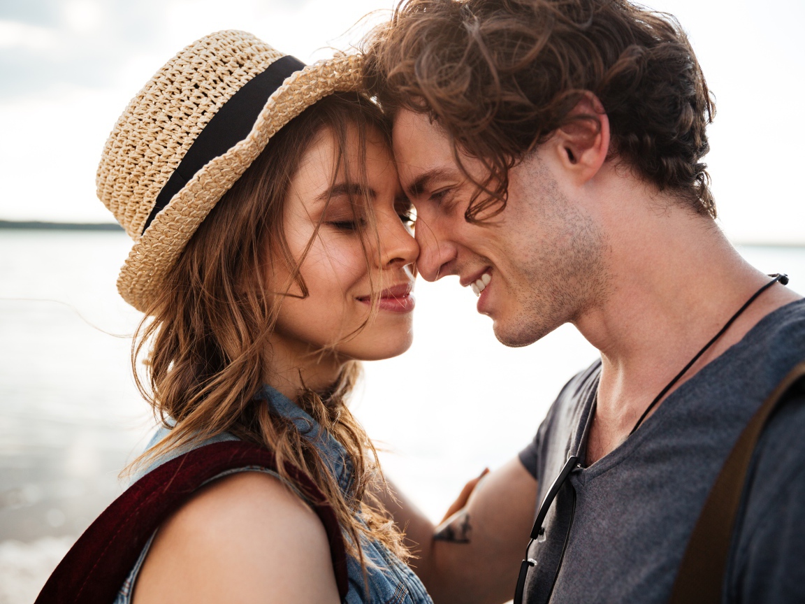 Влюбленная пара стоит на фоне моря 