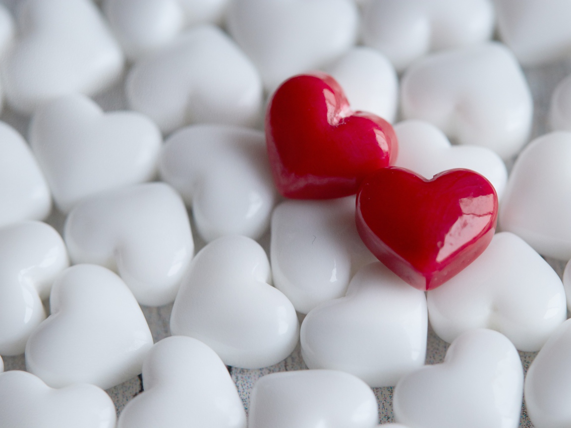 Два красных сердца лежат на белых 