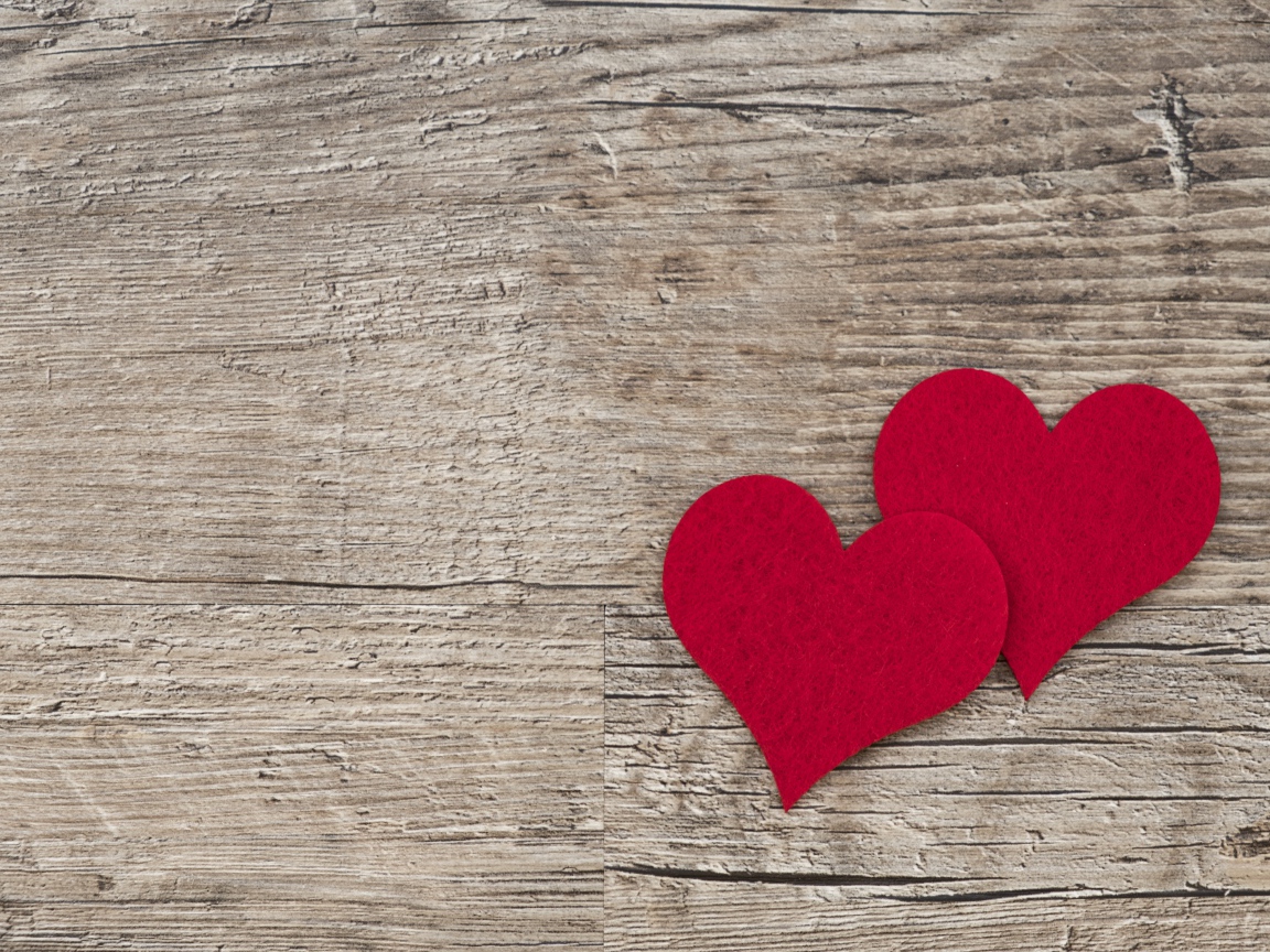 Два красных сердца на деревянном столе