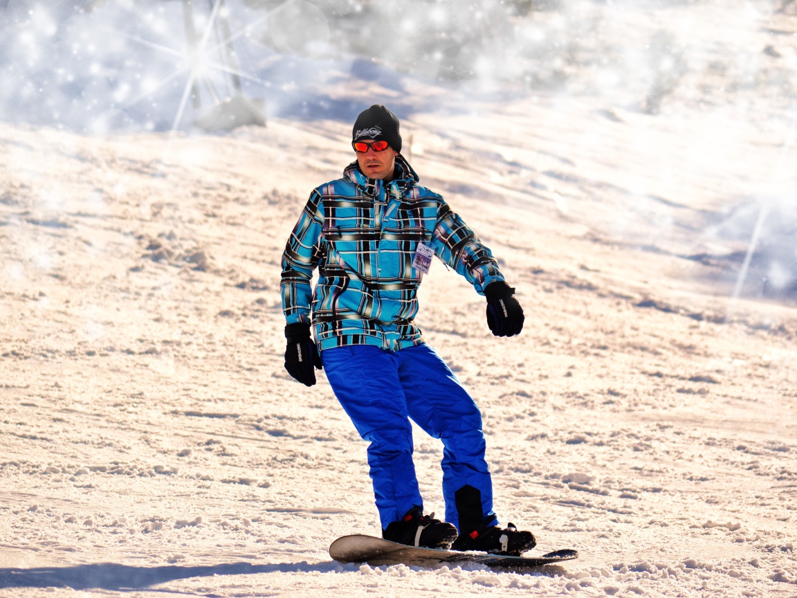 Мужчина сноубордист съезжает с горы 