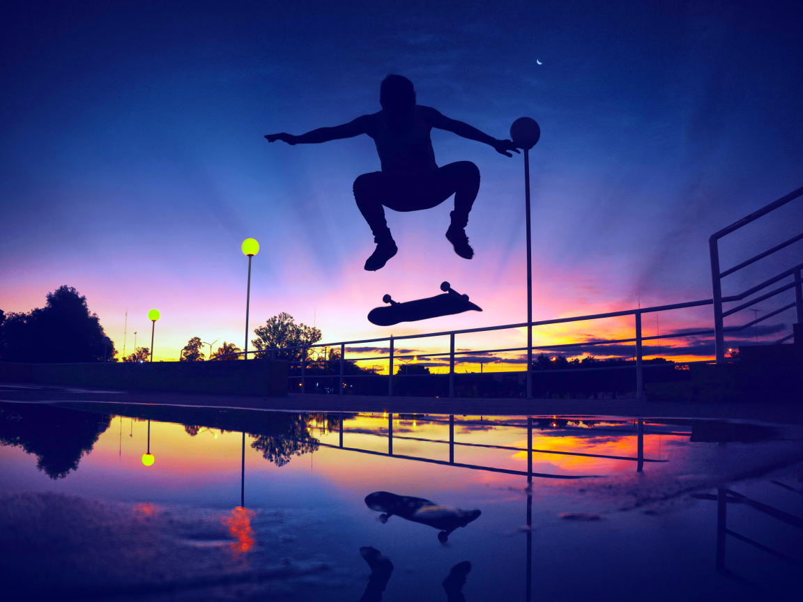 Парень прыгает на скейте на фоне заката