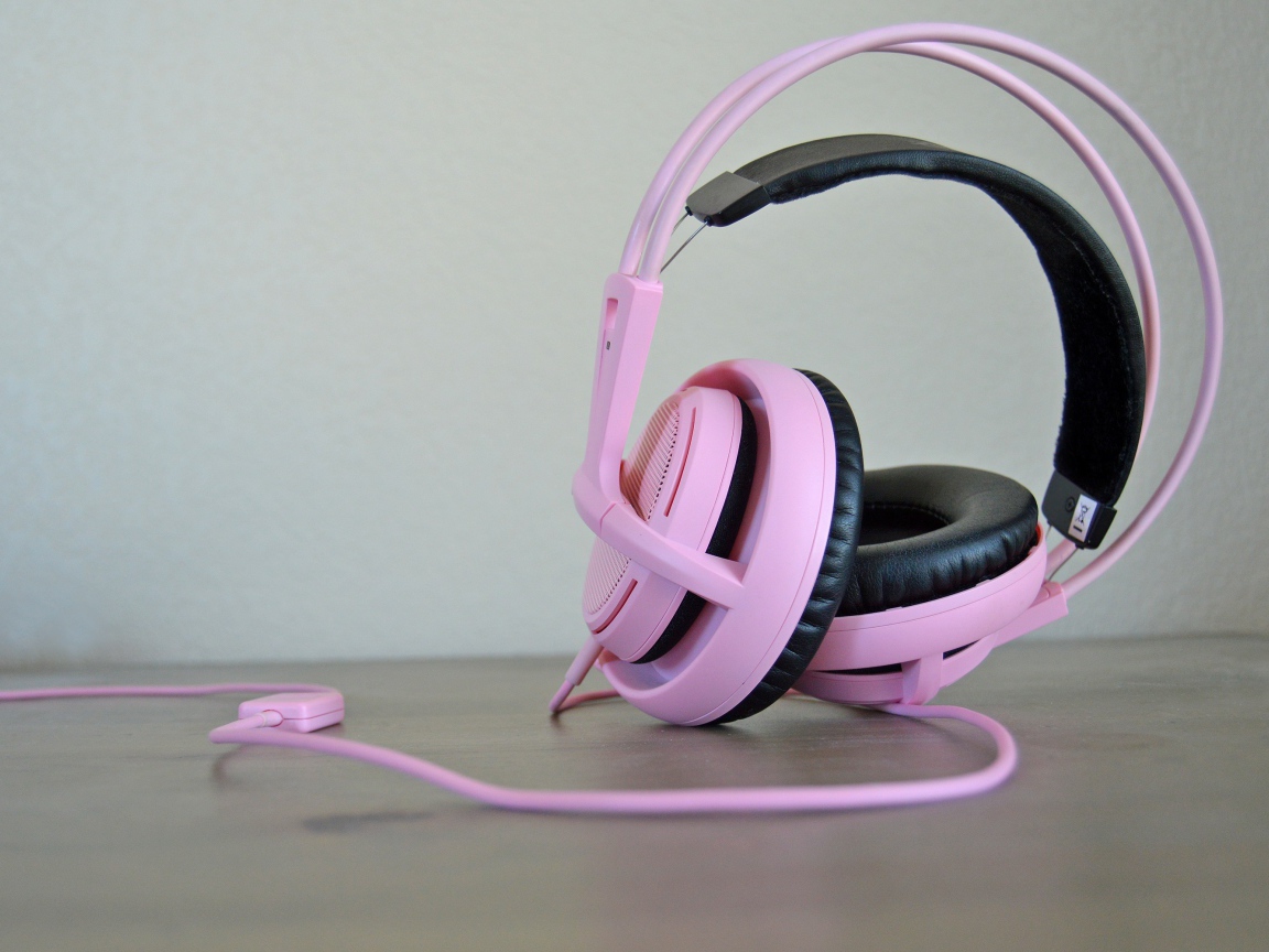 Большие розовые наушники на столе 