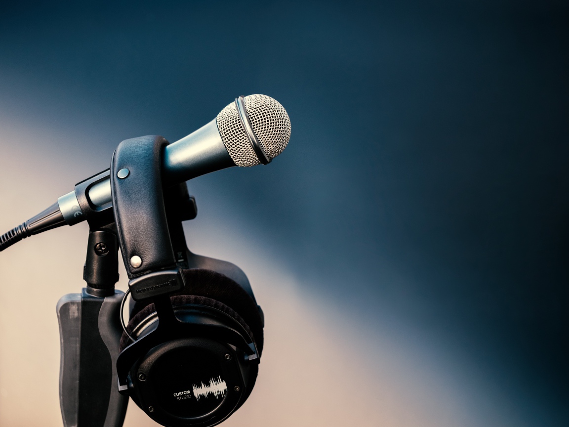Микрофон с черными наушниками на стойке 