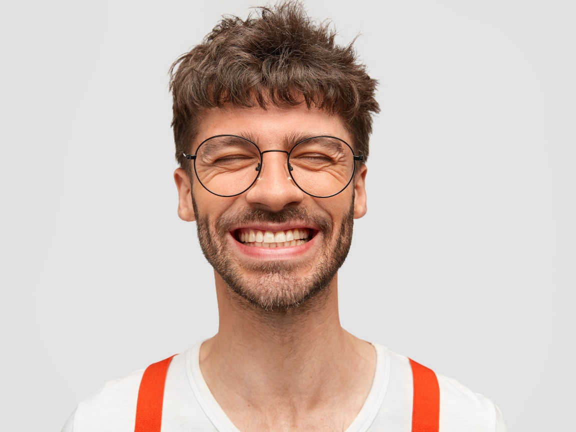 Улыбающийся бородатый мужчина в очках 