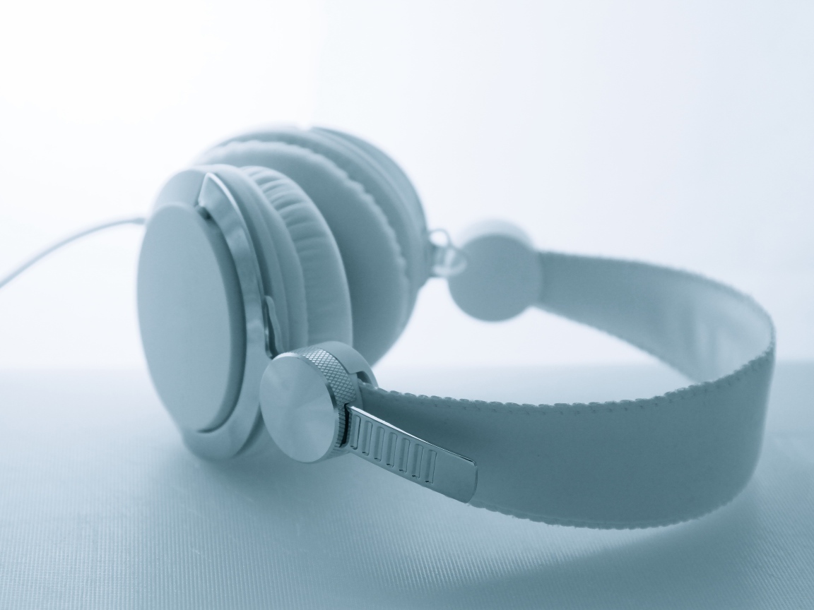 Белые большие наушники лежат на белом фоне