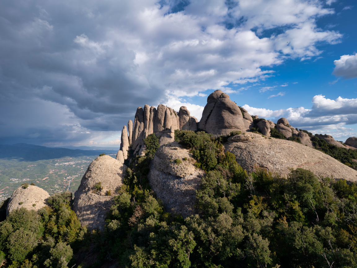 Каменные глыбы под голубым небом с грозовыми облаками 