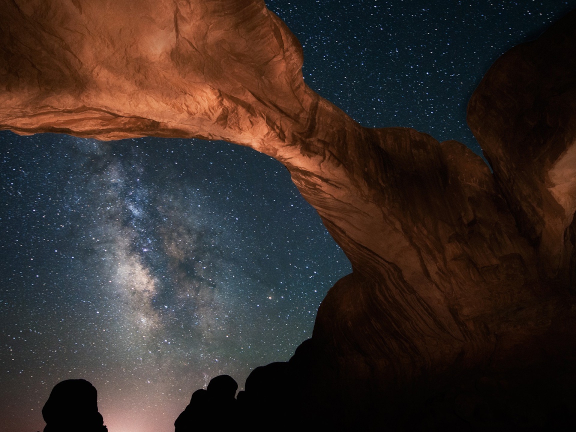 Каменная природная арка под звездным небом ночью 