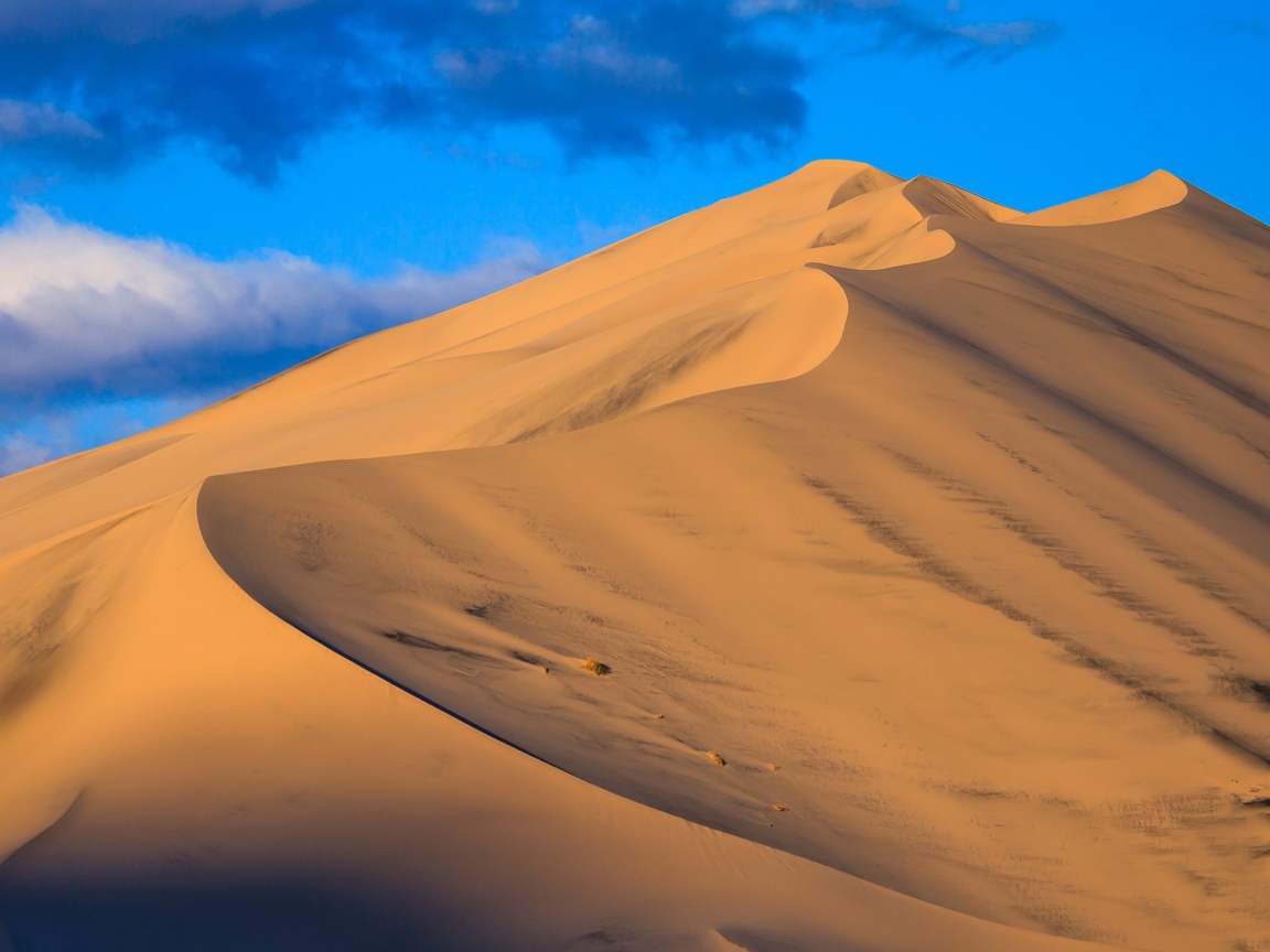 Песчаные дюны под голубым небом 
