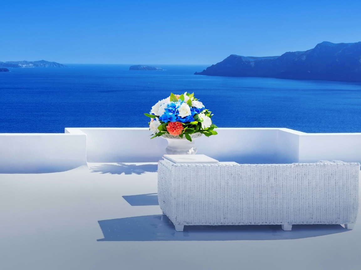 Красивый букет цветов на белом столе на фоне моря