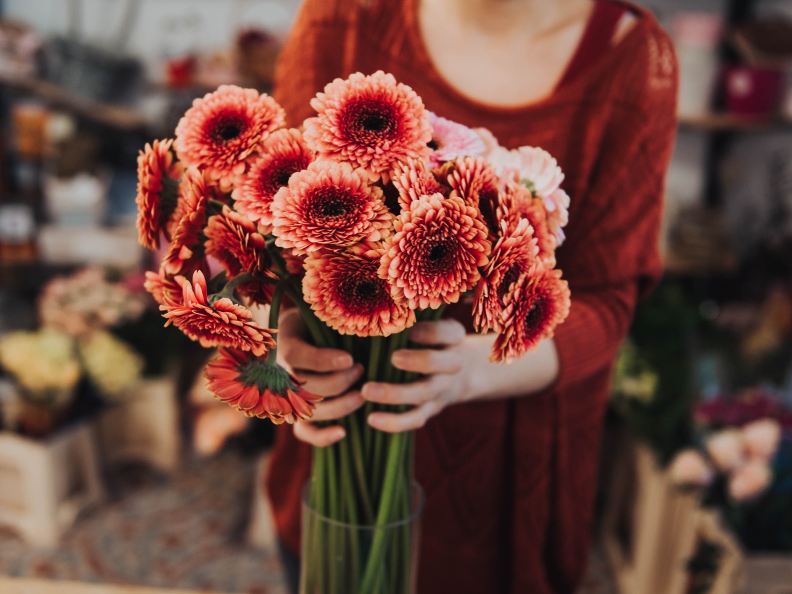 Красивый букет оранжевых гербер в руках у женщины 