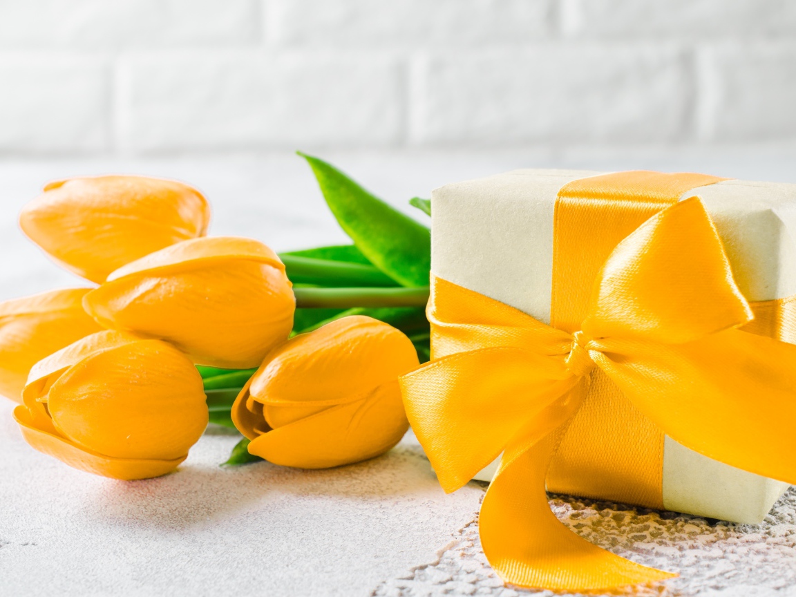 Красивый букет желтых тюльпанов с подарком