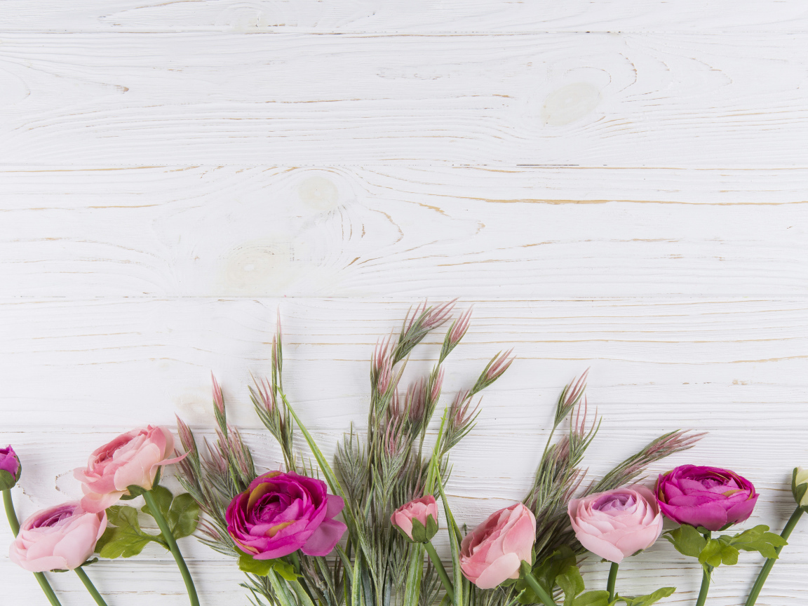 Букет разноцветных лютиков на белом столе