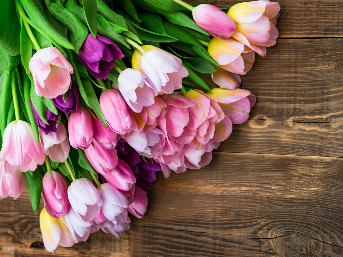 Букет розовых тюльпанов на деревянном фоне