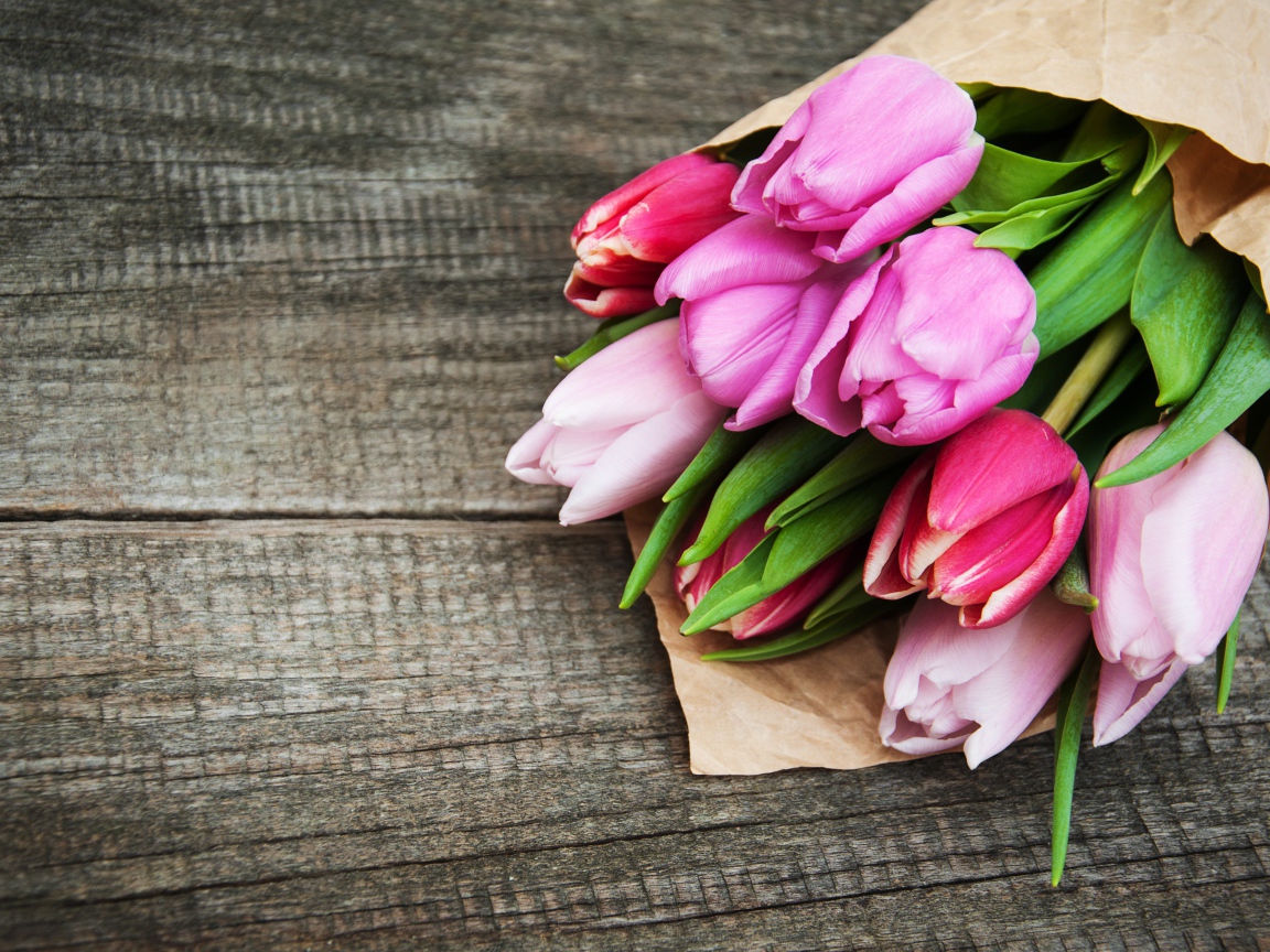 Букет розовых тюльпанов на деревянном столе 