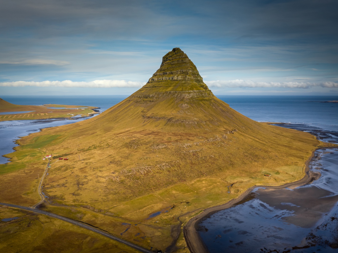 Зеленая гора Киркьюфетль под голубым небом, Исландия