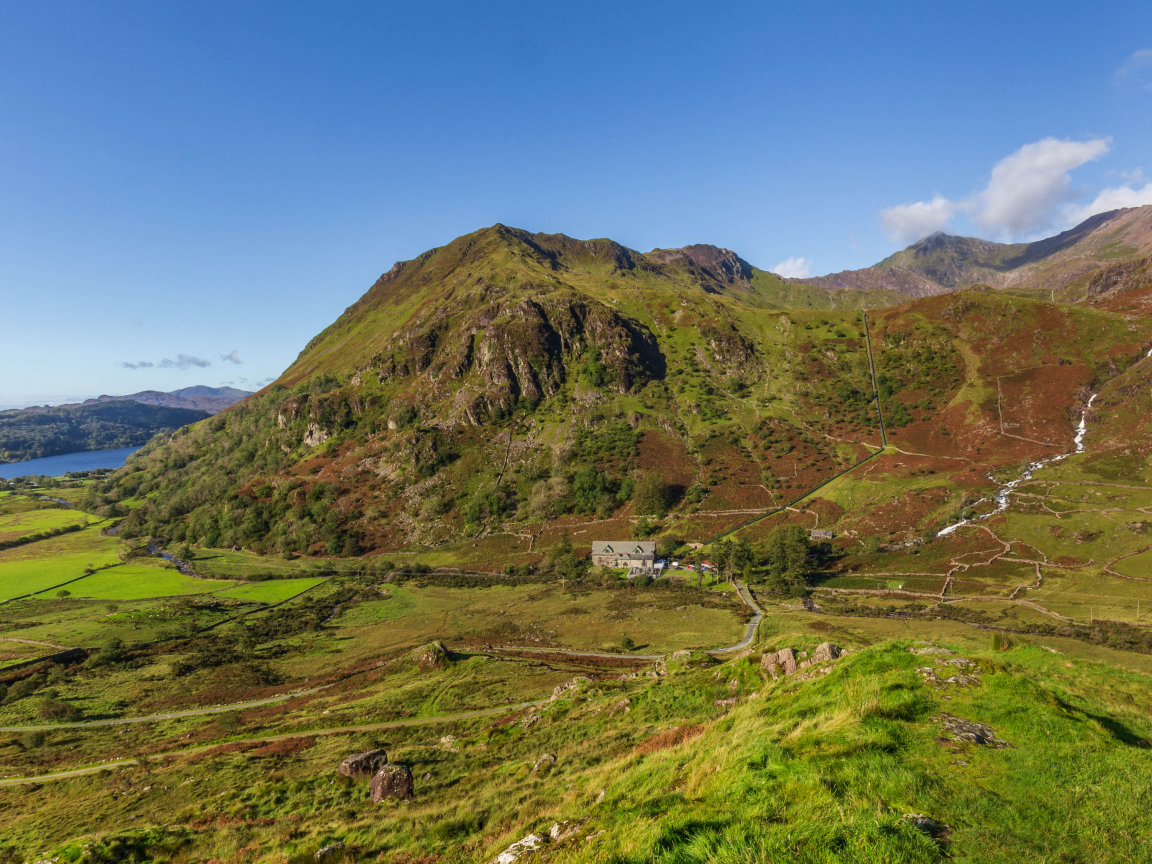 Вид на покрытую зеленью гору под голубым небом