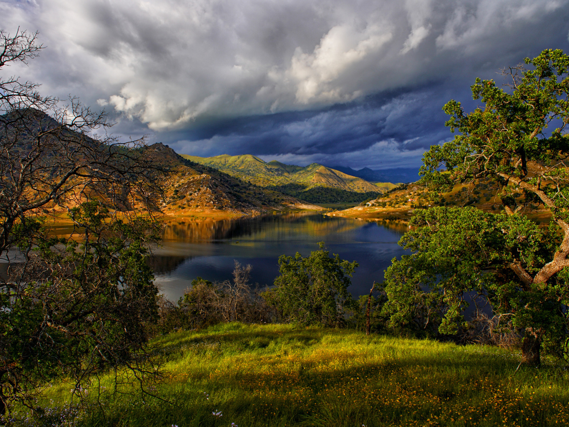 Черные грозовые облака над озером в горах 