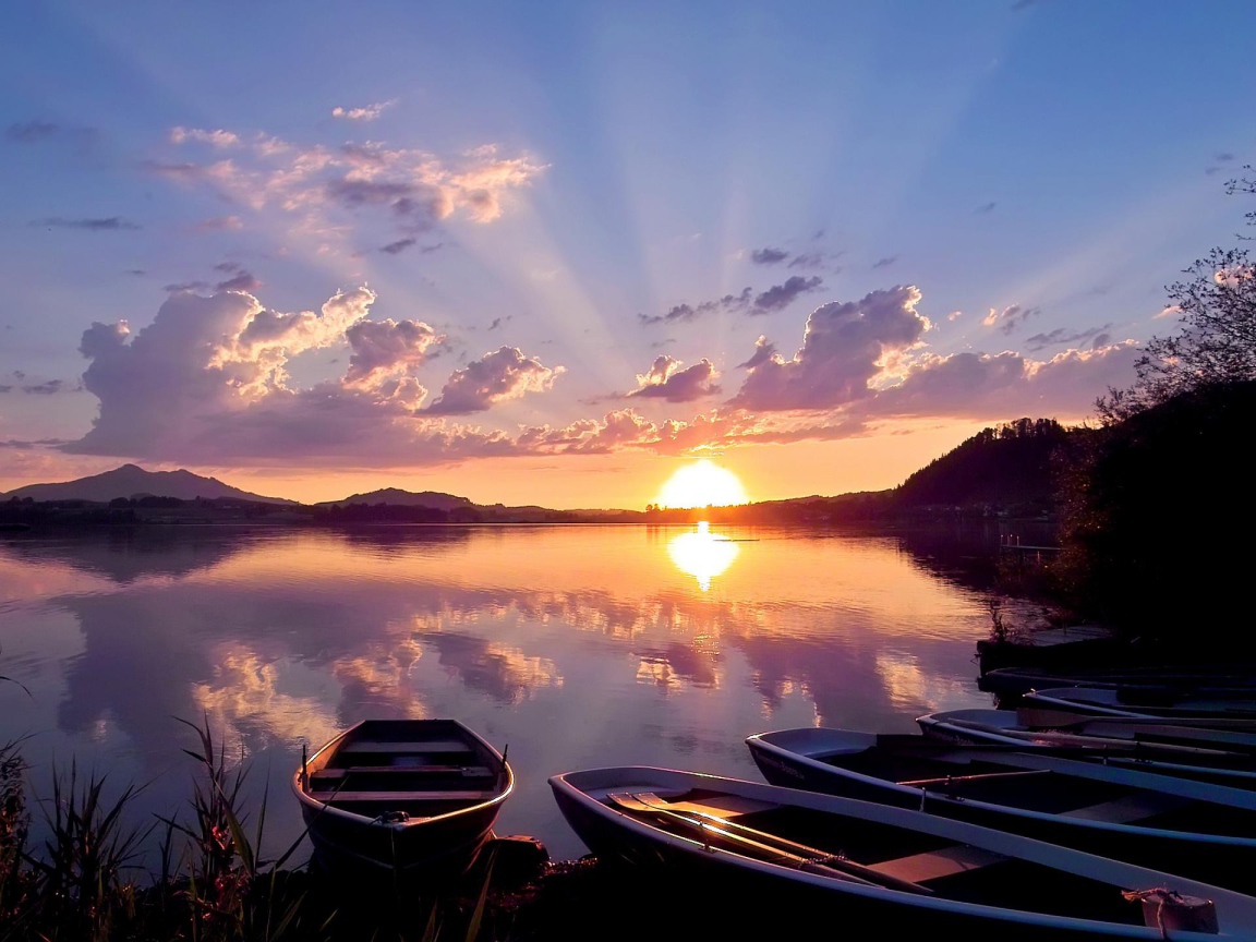 Лодки на берегу озера на закате солнца