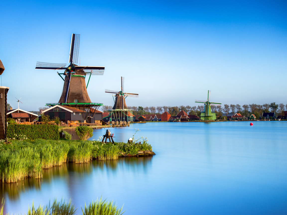 Мельницы  на берегу озера под голубым небом 