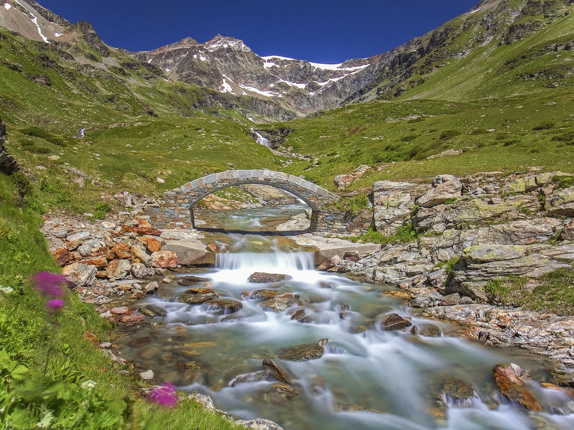 Маленький каменный мост через горную реку 