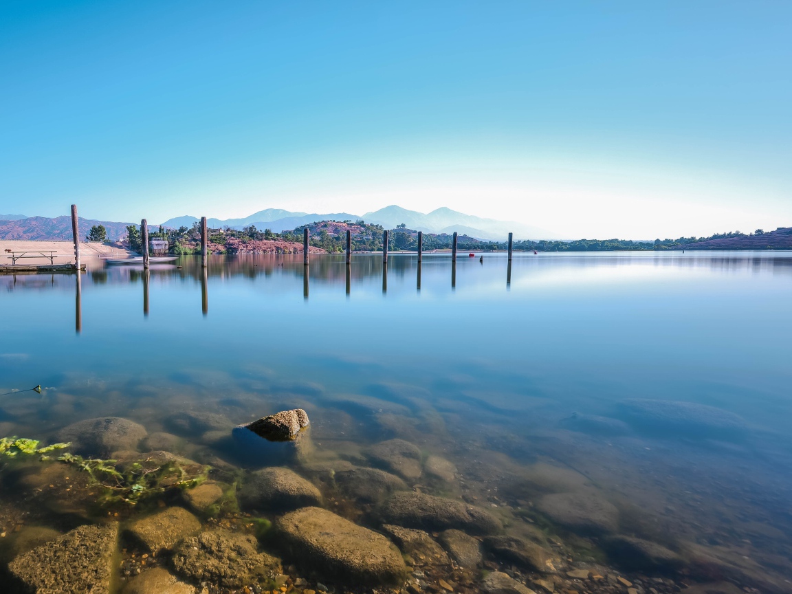 Камни в озере на фоне голубого неба