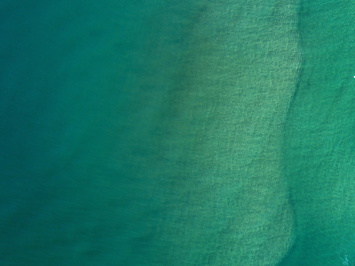 Вид сверху на спокойную голубую гладь океана