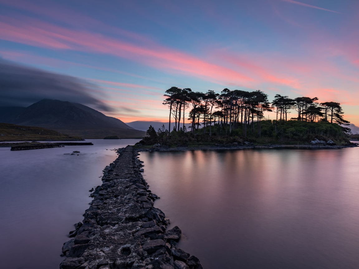 Дорога ведет к острову на фоне голубого заката