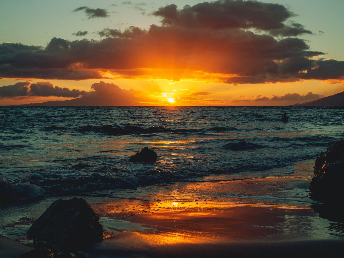 Мокрый песок на берегу океана на закате