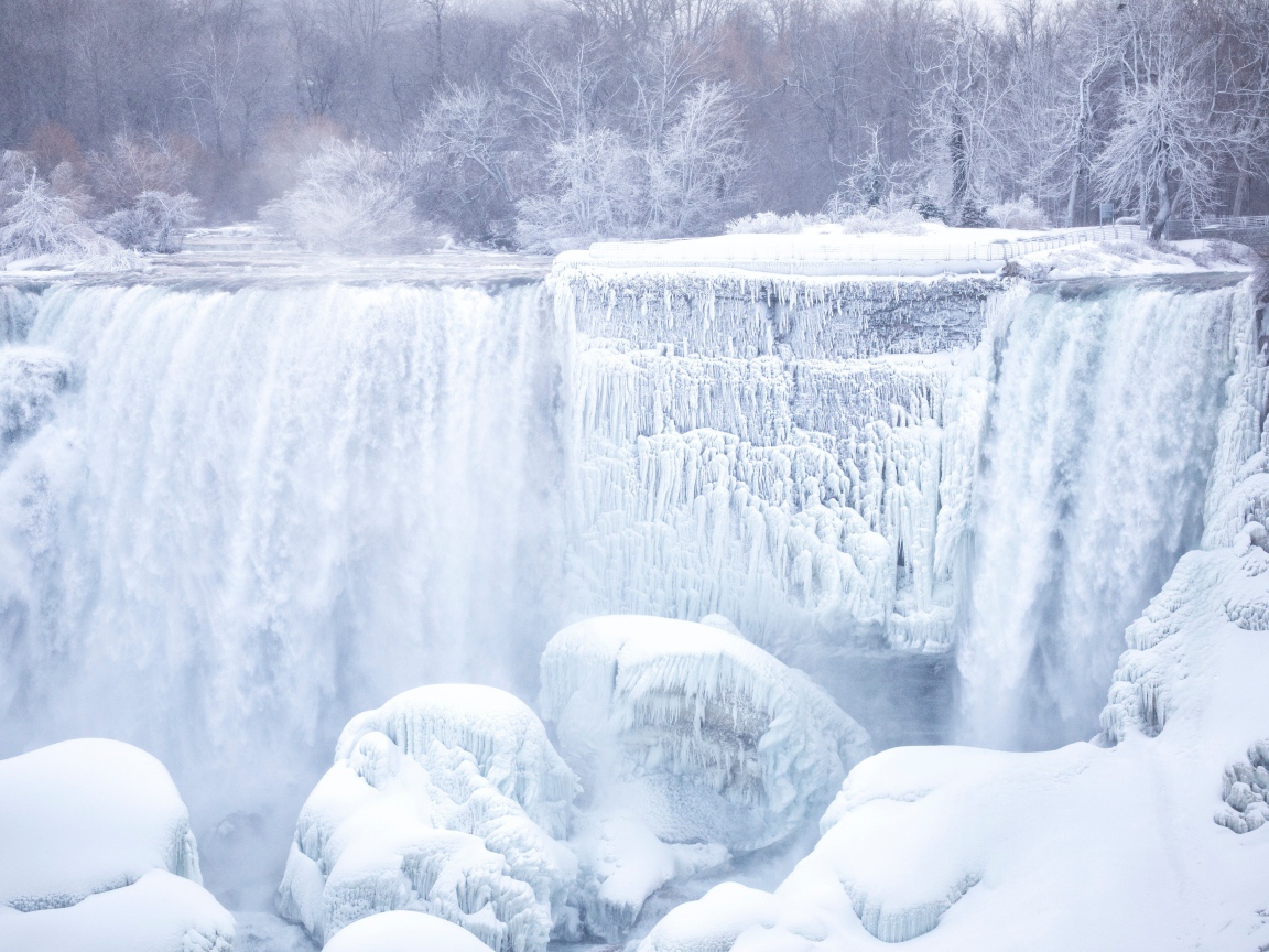 Замерзший водопад стекает по камням зимой