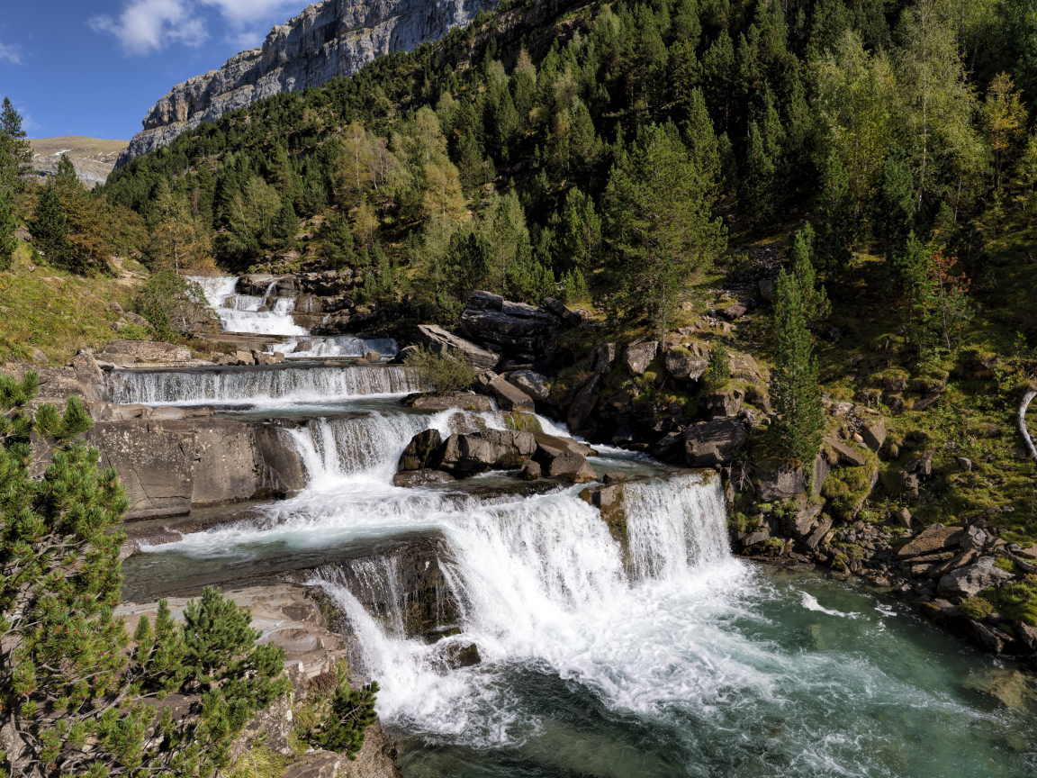 Красивые каскады водопада у скалы 