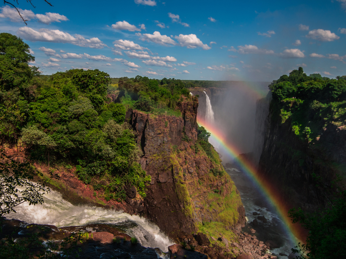 Радуга над водопадом на утесе 