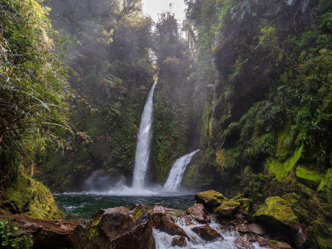 Водопад стекает со скалы в горную реку