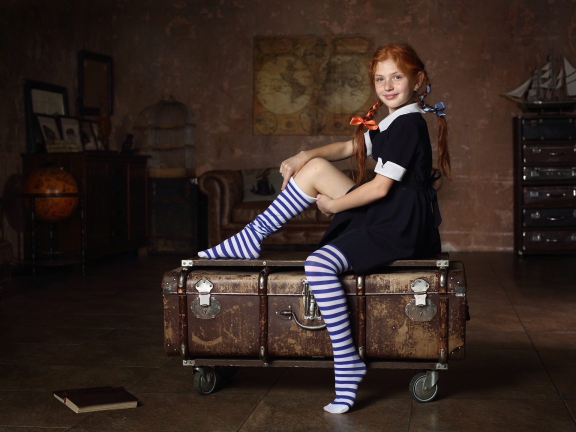Девочка в школьной форме сидит на чемодане 