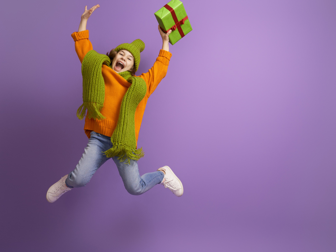 Счастливая девочка с подарком в руке на фиолетовом фоне