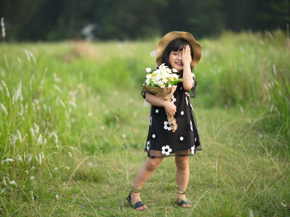 Маленькая девочка с букетом закрыла глаз 