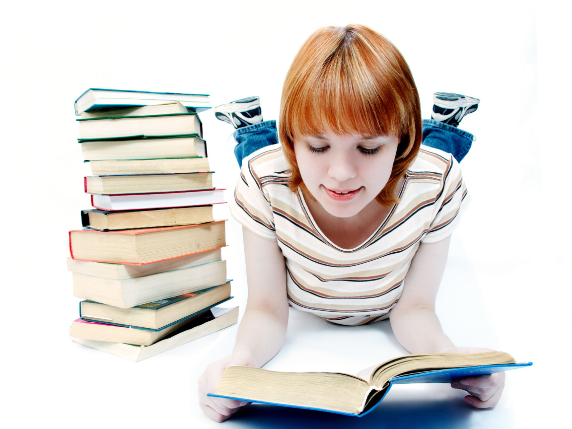 Рыжеволосая девочка школьница читает книги на белом фоне 