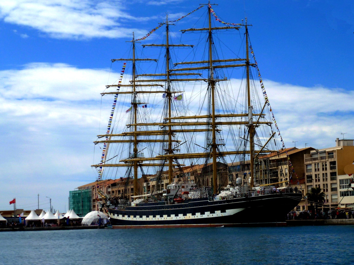Большой парусный фрегат в порту на фоне неба