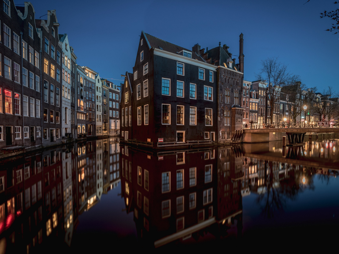 Высокие дома между каналов вечером, Амстердам. Нидерланды
