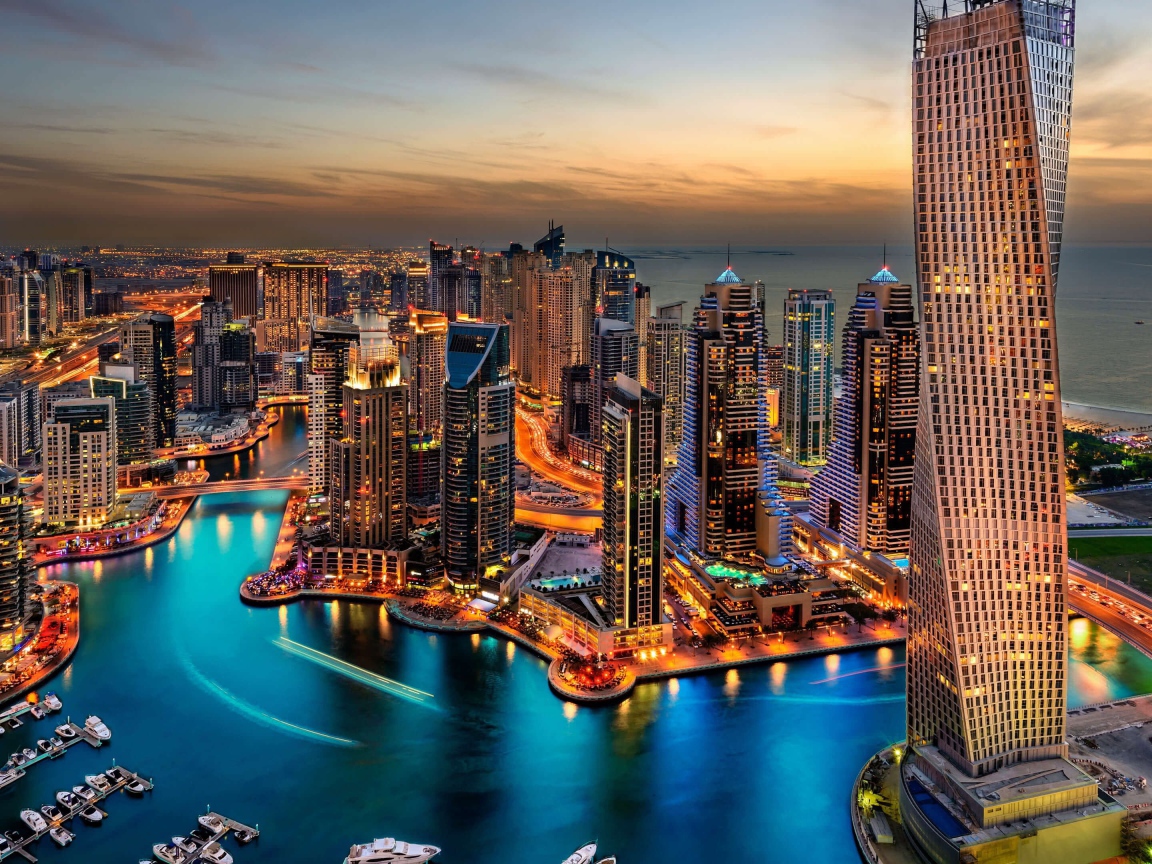 Высокие небоскребы ночного города Дубай у воды 