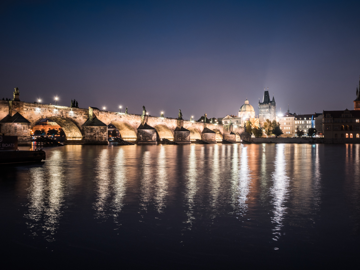 Charles Bridge is reflected in the water at night, Prague Czech Republic