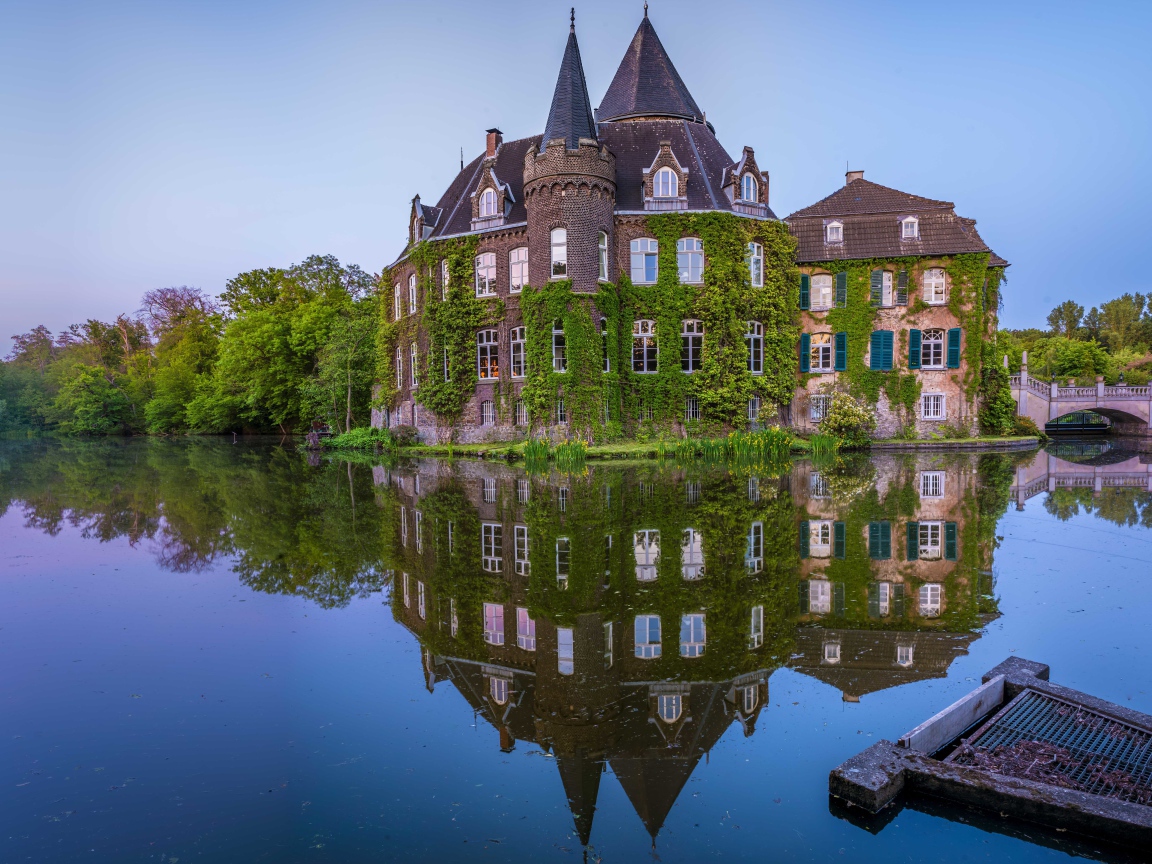 Старинный покрытый зеленью замок Линнеп отражается в воде