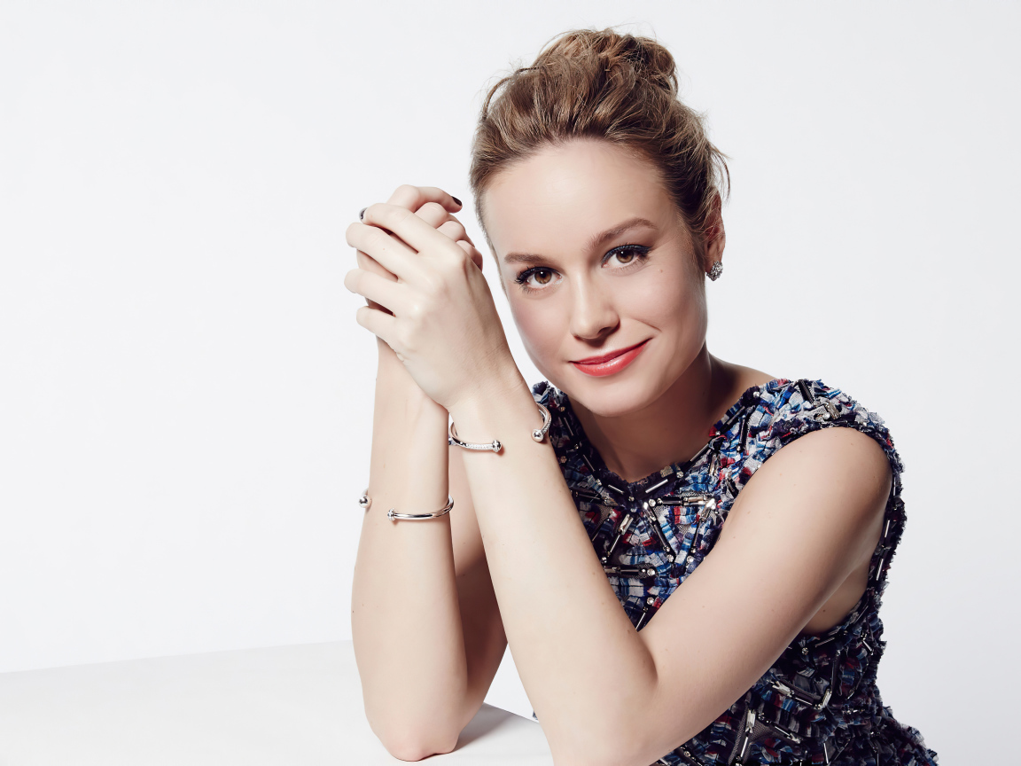 Актриса Бри Ларсон с милой улыбкой на белом фоне