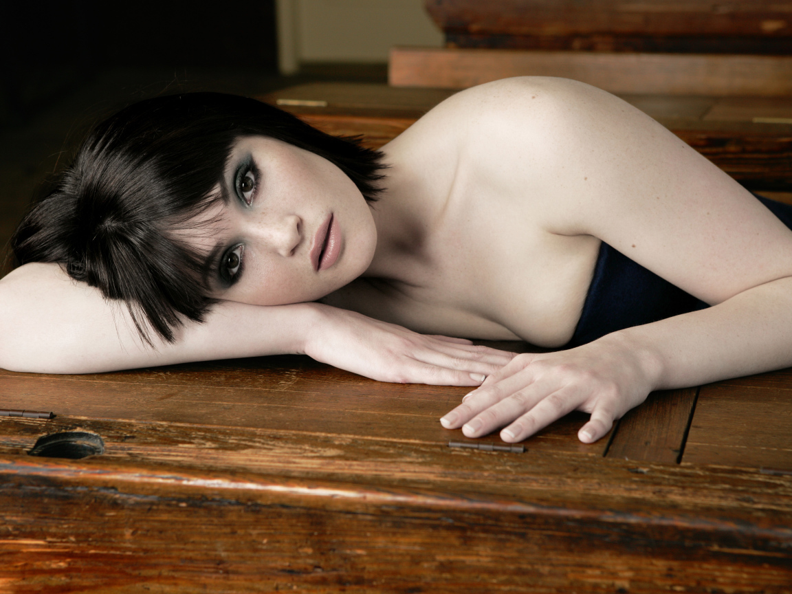 Актриса Джемма Артертон лежит на деревянном столе