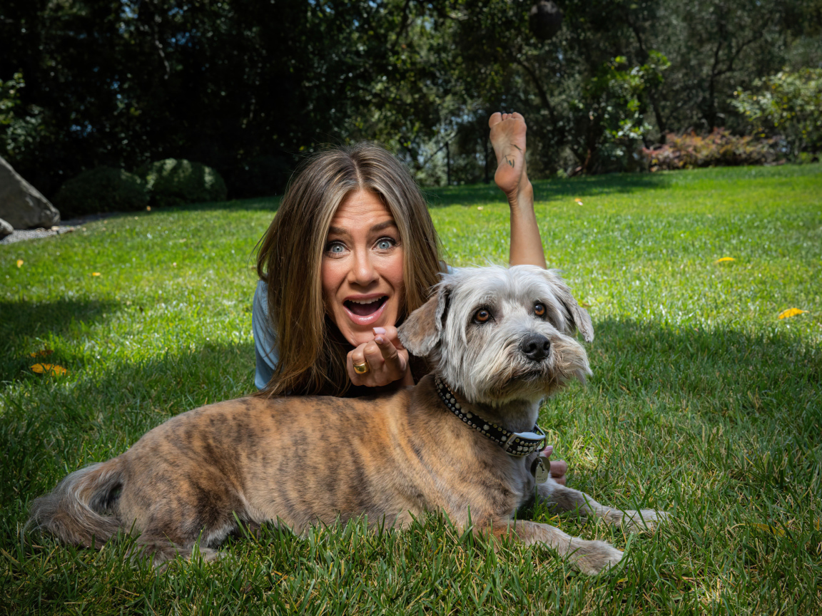 Актриса Дженнифер Энистон с собакой лежит на траве