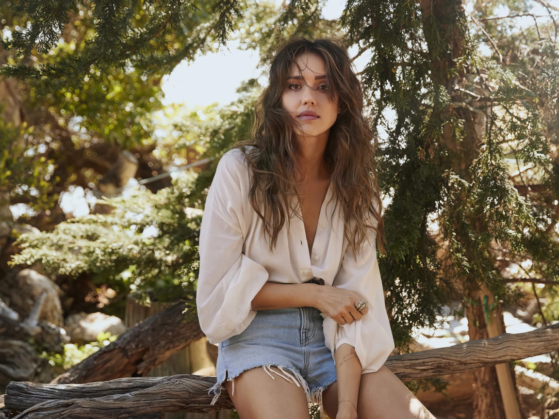 Актриса Джессика Альба сидит на сухом дереве 