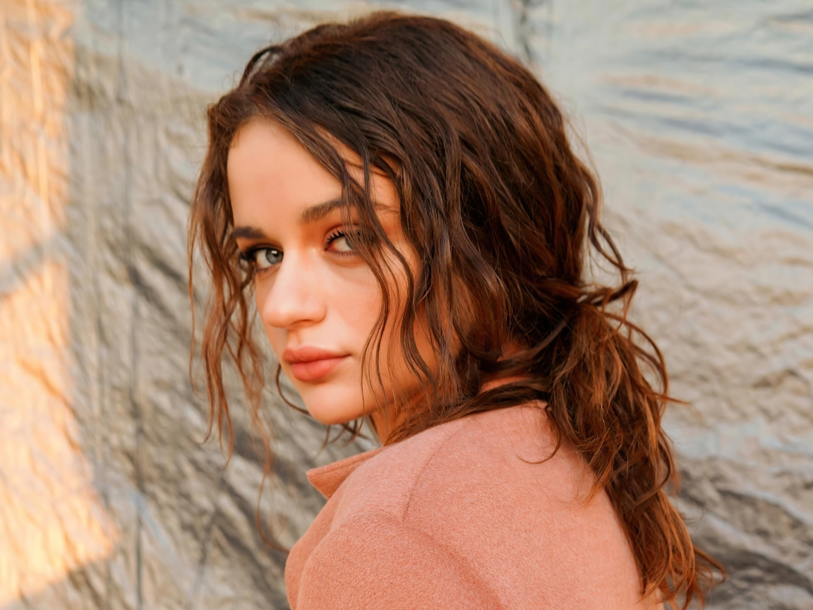 Актриса Джои Кинг стоит боком у стены 