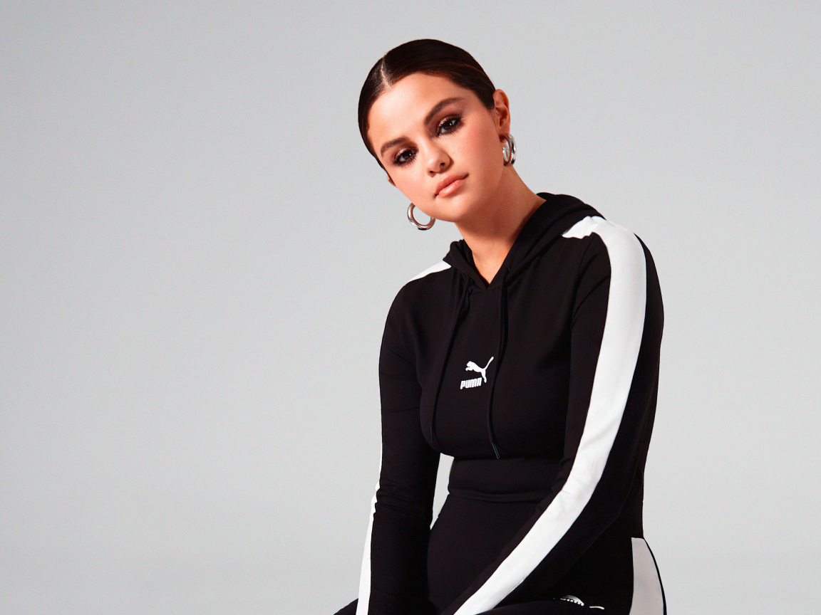 Актриса, модель Селена Гомес в спортивном костюме на сером фоне