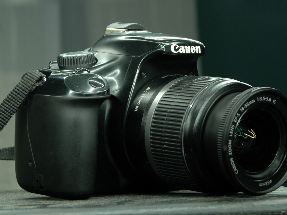 Фотоаппарат Canon 1100D лежит на столе