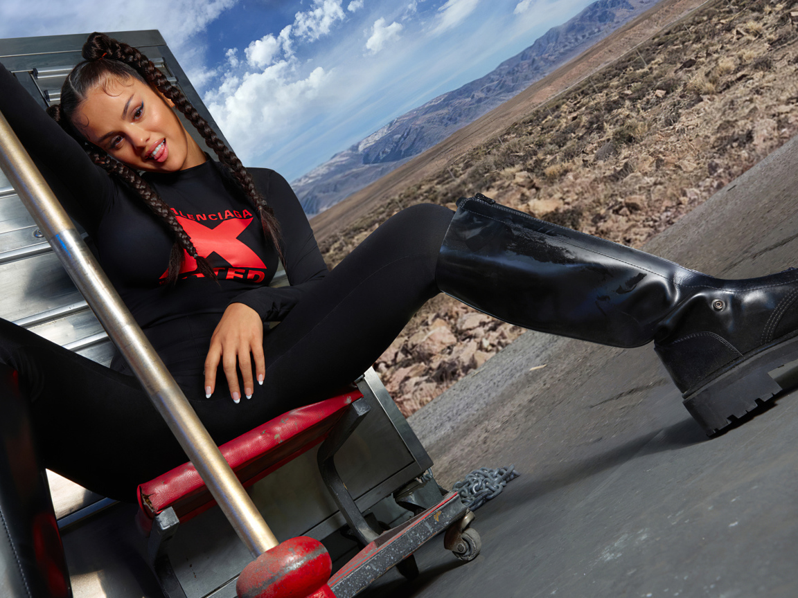 Смешная девушка, певица и актриса Селена Гомес сидит на стуле